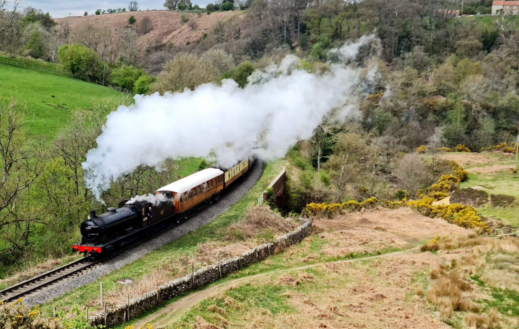 Steam Train in the moors a train on a track with smoke coming out of it