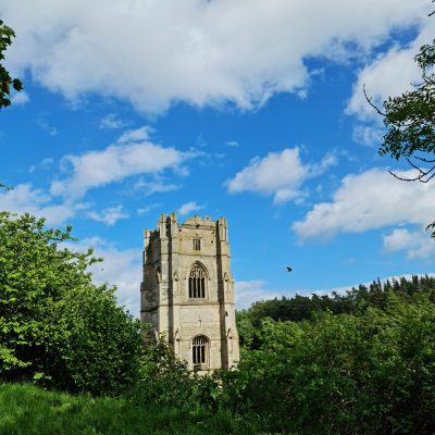 a large clock tower in the middle of a field
