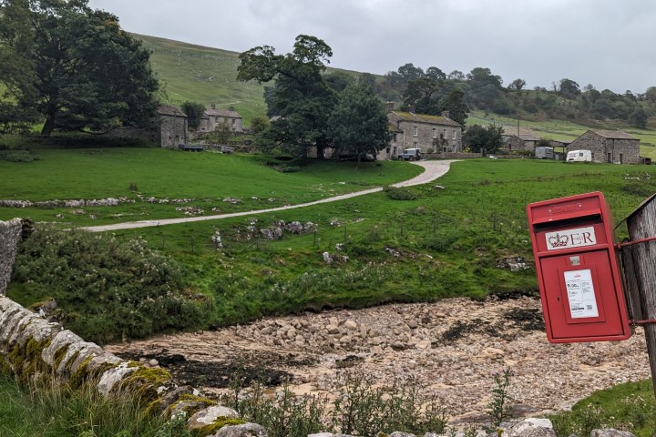 a sign on the side of a dirt field