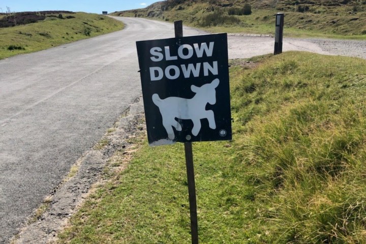 a sign on the side of a dirt road