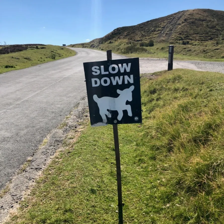 a sign on the side of a dirt road
