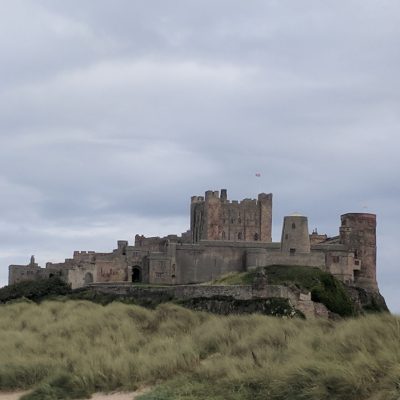 a castle on a cloudy day with Bamburgh Castle in the background