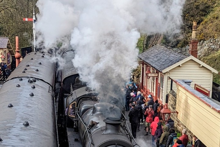 a steam train on a track with smoke coming out of it