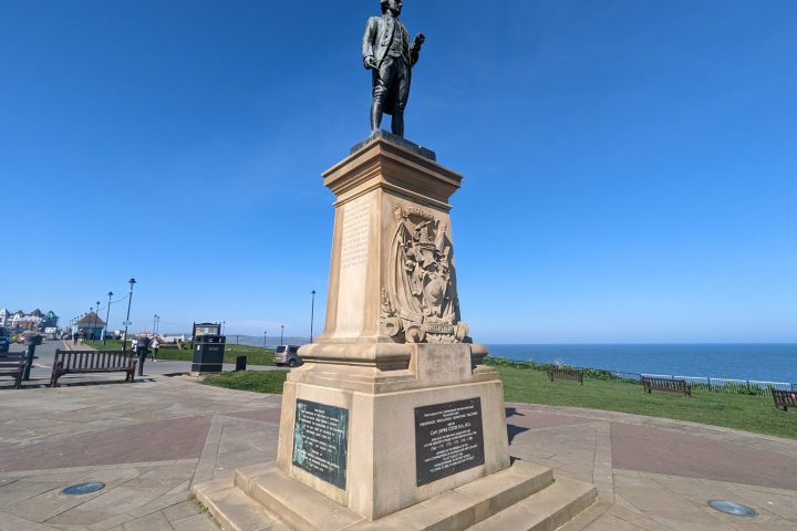 a clock tower in the middle of a sidewalk