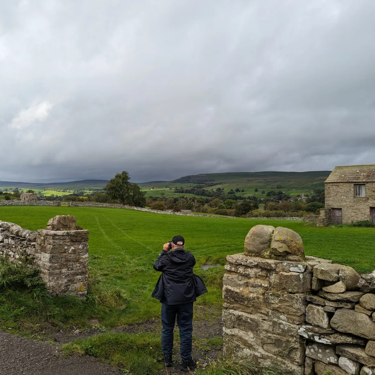 a person standing next to a stone wall